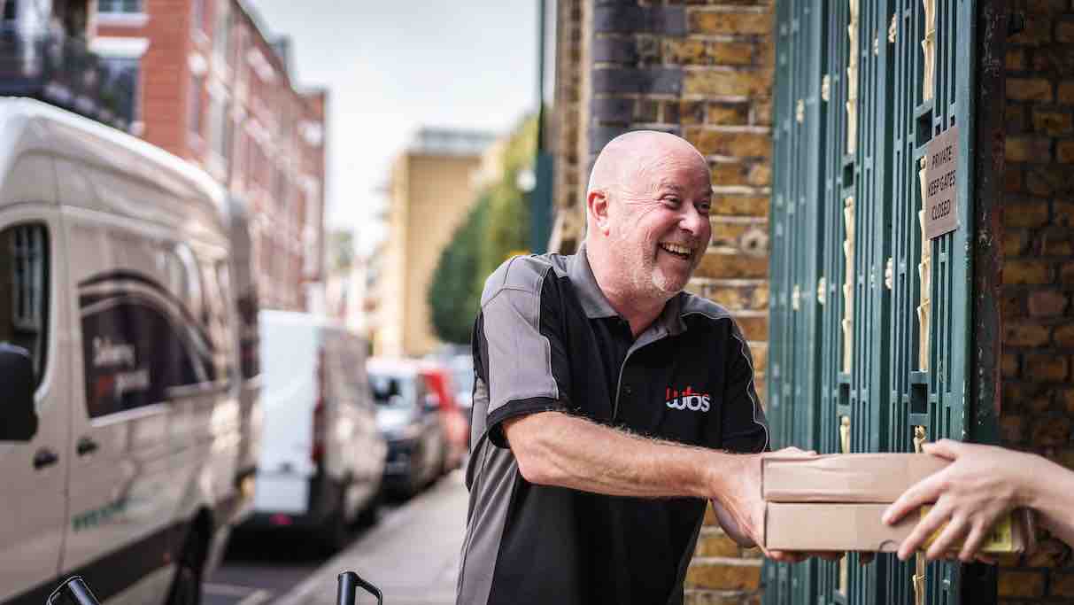 WBS Delivery employee hading in a parcel to a customer's door